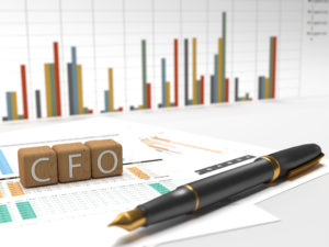 3 wooden dice containing the letters cfo with charts on the background.