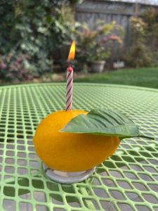 This is a picture of a lemon with a candle in it.